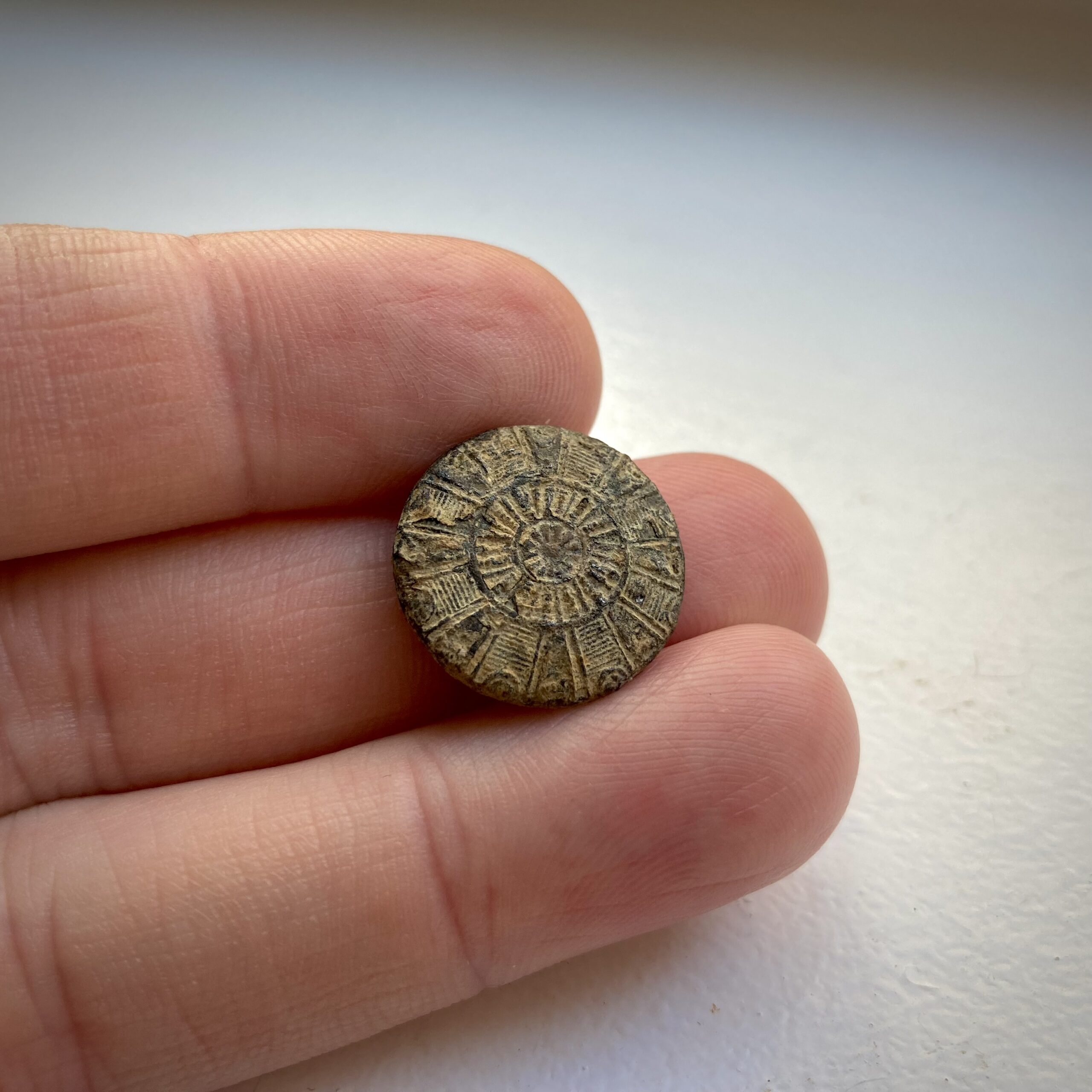 Button with radiating lines design